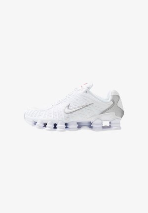 Biały but do biegania Nike ze srebrnym logo, siateczkową cholewką i unikalną segmentowaną podeszwą z kolumnami absorbującymi wstrząsy.