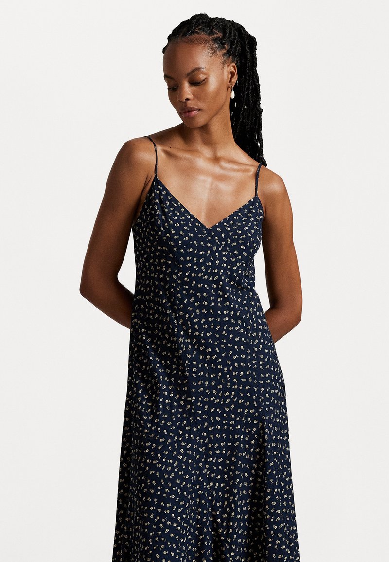 Navy blue floral dress with a V-neckline and thin straps, featuring a lightweight fabric and an A-line silhouette. Small white and yellow flowers design.