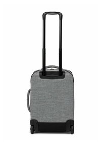 Valise en tissu gris avec une poignée extensible noire, une poignée latérale et deux roues sur un fond blanc.