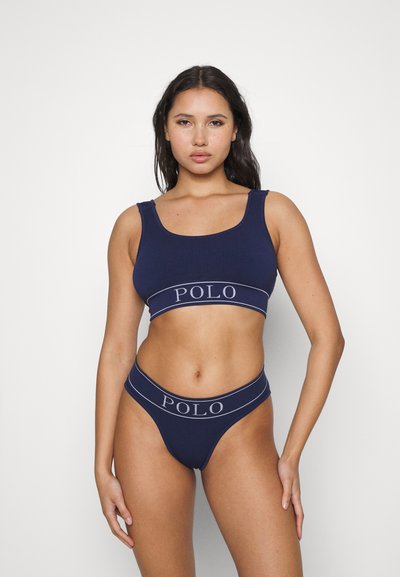 Jūras spēks ribota sporta krūštura un tanga komplekts ar kontrastējošu "POLO" logo joslu. Stiepto audumu ar ciešu piegulšanu un plašām siksnām.