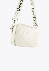 Borsa a tracolla rettangolare bianca con testo embossato "LOLA CSDMNT" e tracolla bianca staccabile con lettering nero "CSDMNT" e icone a forma di cuore.