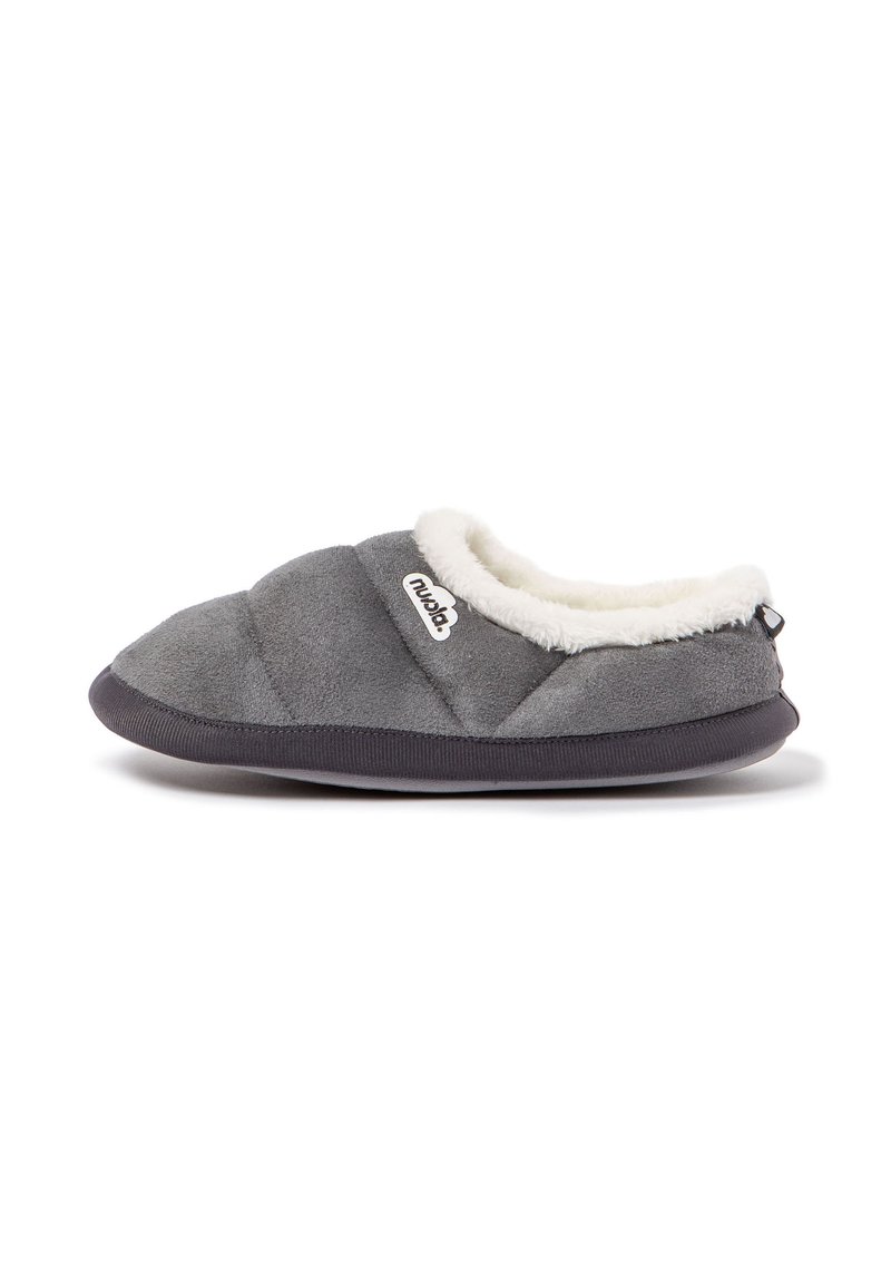 Zapatillas grises con un suave forro de piel sintética blanca, parte superior acolchada y suela de goma negra. Presentan un logo en el costado y un diseño de tipo fácil de poner.