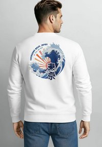 Weißes Sweatshirt mit einem lebendigen blauen Wellenmuster, japanischem Text und einem Sonnenstrahlenmuster auf dem Rücken. Weicher Stoff, Rundhalsausschnitt.