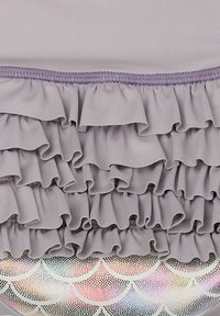 Tissu violet clair plissé avec des plis superposés, présentant une finition texturée, sur un motif festonné scintillant et multicolore.