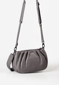 Gray leather handbag with pleated design, adjustable crossbody strap, and textured finish. Features metal hardware for secure attachment.