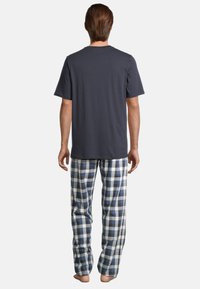 Il pigiama da uomo presenta una t-shirt grigia a maniche corte abbinata a pantaloni a quadri blu e bianchi realizzati in tessuto morbido.