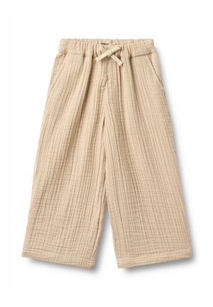 Pantalon beige ample pour enfant en tissu texturé, taille élastique, cordon de serrage et poches latérales, présenté sur fond blanc.