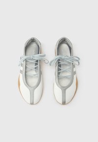 Λευκά και γκρι παπούτσια με επίπεδη σόλα και στρογγυλεμένη μύτη, με μαλακό δερμάτινο επάνω μέρος, ομοιόχρωμα κορδόνια και εύκαμπτη ελαστική σόλα. Χωρίς ορατά σχέδια.