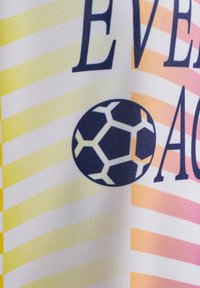 Tygg banner med diagonala ränder i gult, rosa och vitt. Har en mörkblå fotbollsgrafik och fet text.