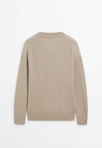 Beige gerippter Strickpullover mit langen Raglanärmeln und rundem Ausschnitt, von hinten auf einem weißen Hintergrund gezeigt.