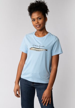 T-shirt en coton bleu ciel à manches courtes avec un graphisme d'une sardine et le texte « Niedliche Sardelle » en dessous du design.