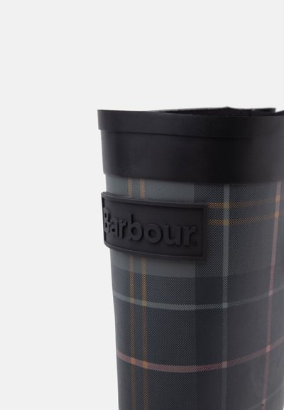 Висок водоустойчив ботуш с черна маншета и тъмен кареен модел с лого Barbour на правоъгълна лепенка.