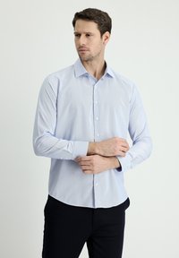 Camicia a maniche lunghe blu chiaro con colletto a punta, chiusura a bottoni e polsini dritti. Realizzata in un tessuto liscio e a trama fine.