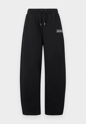 Pantaloni della tuta neri a gamba larga con vita elastica e coulisse, con piccolo logo bianco "jordan" sulla coscia destra.