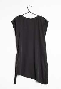 Svart tunika med lös passform, korta ärmar och asymmetrisk nederkant. Har en rund halsringning med guldaccenter och en mjuk, slät textur.