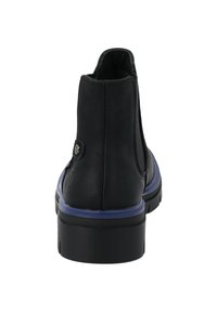 Botín de cuero negro con suela azul y detalle de botón, con una textura suave y forma redondeada. Diseñado para un uso casual.