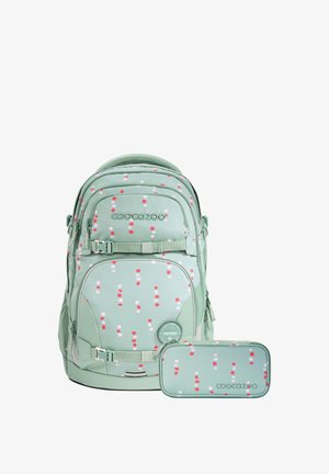 Light green backpack and matching pencil case with red and white dot pattern, featuring multiple compartments and buckle straps.