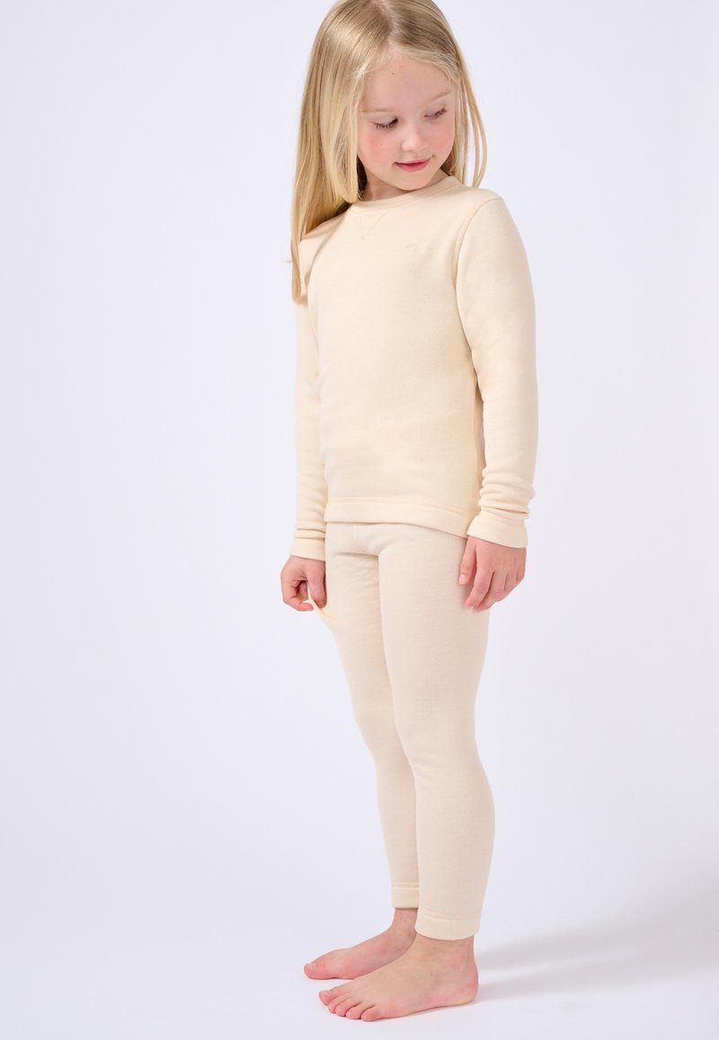 Maglietta termica grigio chiaro e leggings in tessuto a coste, con maniche lunghe e design aderente, mostrati su un bambino in piedi.