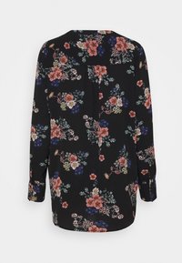 Blouse noire à manches longues avec un motif floral rose, bleu et vert. Conçue avec un col rond et un détail plissé à l'arrière.
