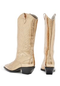 Arany színű cowboy csizmák, hegyes orral, dombornyomott virágmintákkal és alacsony, stílusos sarkakkal. Fényes bőrből, sima textúrával készültek.