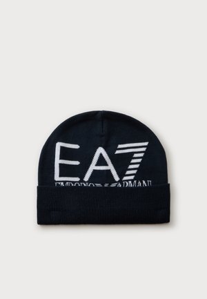 Sort strikket beanie med foldet kant med stort hvidt EA7-logo og delvist synlig Armani-tekst foran.