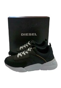 Schwarze Sportsneaker mit weißen Schnürsenkeln, ausgestattet mit einem strukturierten Obermaterial und goldenen Akzenten an der Seite, kombiniert mit einer eleganten weißen Sohle.