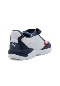 Scarpe sportive con una tomaia in rete bianca testurizzata, dettagli in pelle blu navy, particolari rossi e un cinturino in velcro per una chiusura sicura.