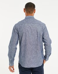 Camicia blu a maniche lunghe realizzata in tessuto testurizzato, con orlo dritto, polsini con bottoni e colletto classico. Vista posteriore che mostra sottili variazioni di colore.