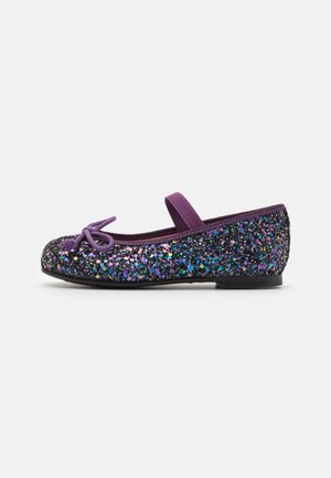 Ballerine plate violette scintillante avec un bout arrondi, une sangle élastique et un détail nœud. La tige est recouverte de sequins multicolores étincelants.