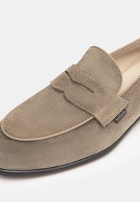 Beige Wildlederloafer mit einer runden Zehenform, einem dekorativen Schleifenakzent und kontrastierenden Nähten. Verfügt über ein glattes Innenfutter und eine flexible Sohle.
