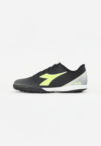 Zapatilla deportiva negra con parte superior texturizada, acentos en amarillo neón y un patrón de puntos. Cuenta con una entresuela blanca y una suela de goma para tracción.