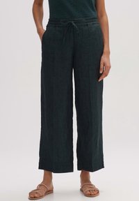 Vida vida byxor i mörkgrön linne, med ett elastiskt midjeband och snörning. Det texturerade tyget ger en avslappnad och bekväm passform.