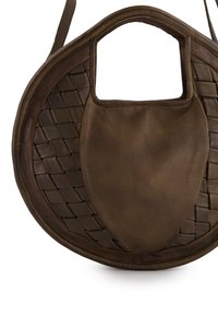 Brown leather bag with a round shape, featuring woven texture on one side and smooth surface on the other, with a cut-out handle.