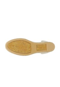 Flat-soled shoe with a textured beige fabric upper and a brown patterned rubber sole. Features a reinforced heel and smooth edges.