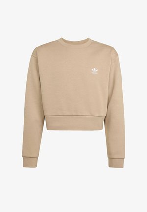 Lyhyt beigellä sävyllä valmistettu pehmeästä kankaasta tehty collegepaita, jossa on pitkä hiha, pyöreä pääntie ja pieni valkoinen Adidas-logo rinnassa.