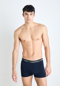 Sötétkék csíkos boxer sort puha anyagból. Az elasztikus derékpánton fehér "KARL LAGERFELD" logó található. A szabás fitted, és a comb közepéig ér.