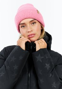 Zwarte gewatteerde jas met sterrenpatroon, hoge kraag en ritssluiting. Roze gebreide muts met textuurpatroon en logo-label.