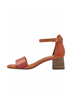 Open-toe heeled sandal featuring a patterned woven strap in pink and orange, a brown leather ankle strap with adjustable buckle, and a chunky heel.