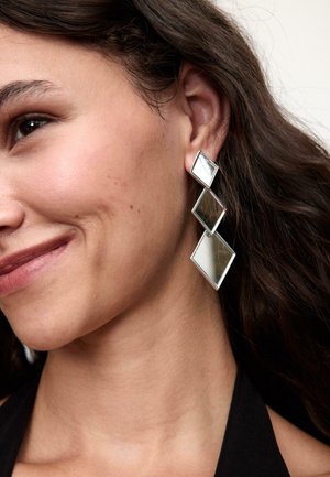 Srebrne kolczyki wiszące z czterema kwadratowymi diamentowymi kształtami, z polerowanym lustrzanym wykończeniem i gładkimi krawędziami. Nadają się do noszenia na formalne i codzienne okazje.
