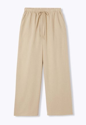 Pantalon beige à jambes larges avec taille élastique, cordon de serrage et poches latérales, présenté sur fond blanc.