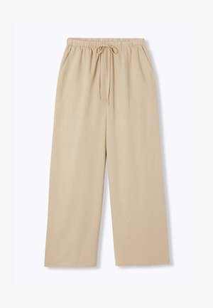 Pantalon beige à jambes larges avec taille élastique, cordon de serrage et poches latérales, présenté sur fond blanc.
