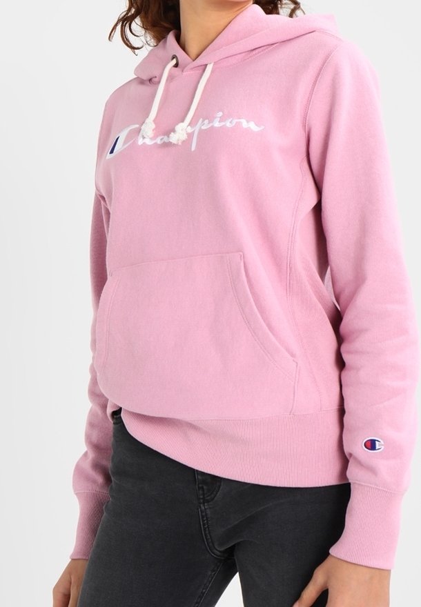 Felpa con cappuccio di colore rosa chiaro, dotata di tasca frontale e cordini, con il logo "Champion" ricamato in bianco. Polsini e orlo a costine.