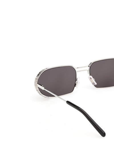 Sølvmetal-rammede solbriller med rektangulære mørketonede glas og sorte plastikender på stellet mod en hvid baggrund.