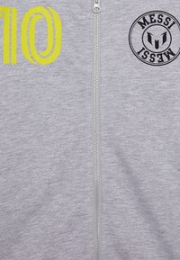 Felpa con zip grigia con un grande grafico giallo "10" a sinistra e un logo circolare nero "MESSI" a destra. Tessuto morbido.