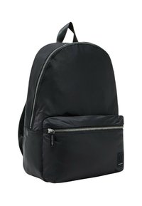 Mochila negra de nailon con parte superior redondeada, bolsillo frontal con cremallera, correas ajustables y un acabado texturizado. Presenta acentos de hardware plateado.