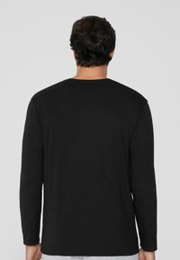 Schwarzes langärmeliges T-Shirt, Rundhalsausschnitt, weiche Baumwollmischung, taillierte Passform, glatte Textur, keine sichtbaren Muster oder Hardwaredetails.