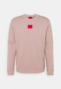 Sudadera rosa claro hecha de algodón. Cuenta con cuello redondo, mangas largas y un parche de logo cuadrado rojo con "HUGO" en el centro.