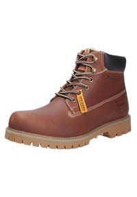 Bottine en cuir marron avec bout rond, semelle en caoutchouc, œillets en métal, couture contrastée et étiquette logo sur le côté.