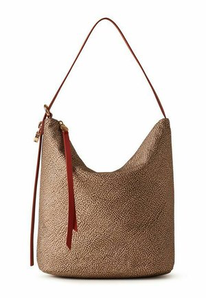 Sac hobo en cuir marron texturé avec une longue bandoulière et une fine pampille en cuir rouge sur la fermeture éclair sur fond blanc.