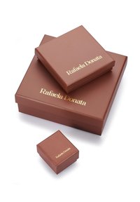 Scatole regalo marroni di diverse dimensioni, con una superficie liscia e il marchio dorato "Rafaela Donata" sui coperchi. Tre scatole impilate.